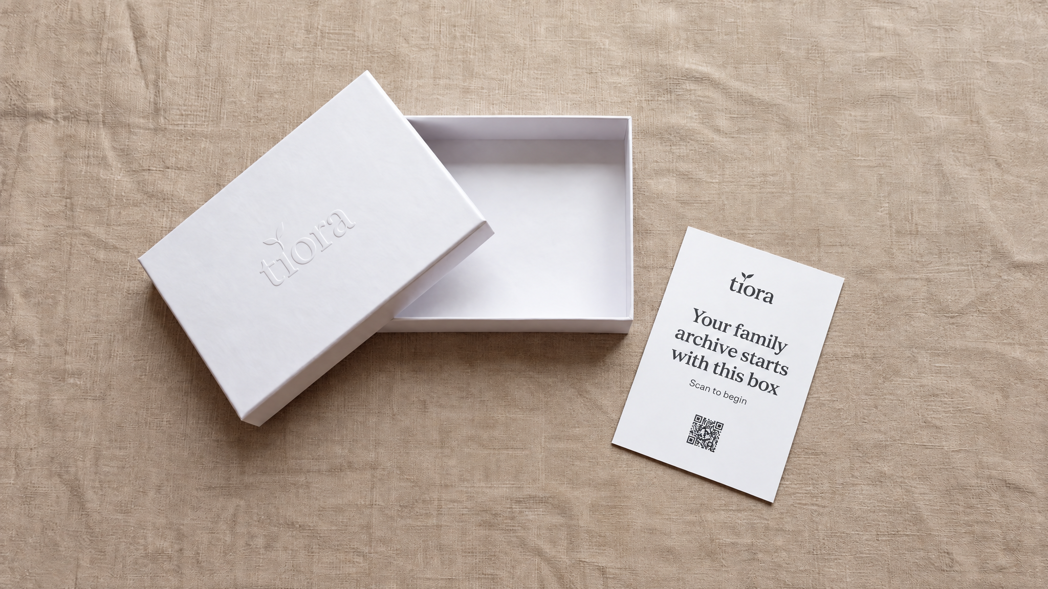 An open Tiora archive box beside a card reading 'Your family archive starts with this box'
