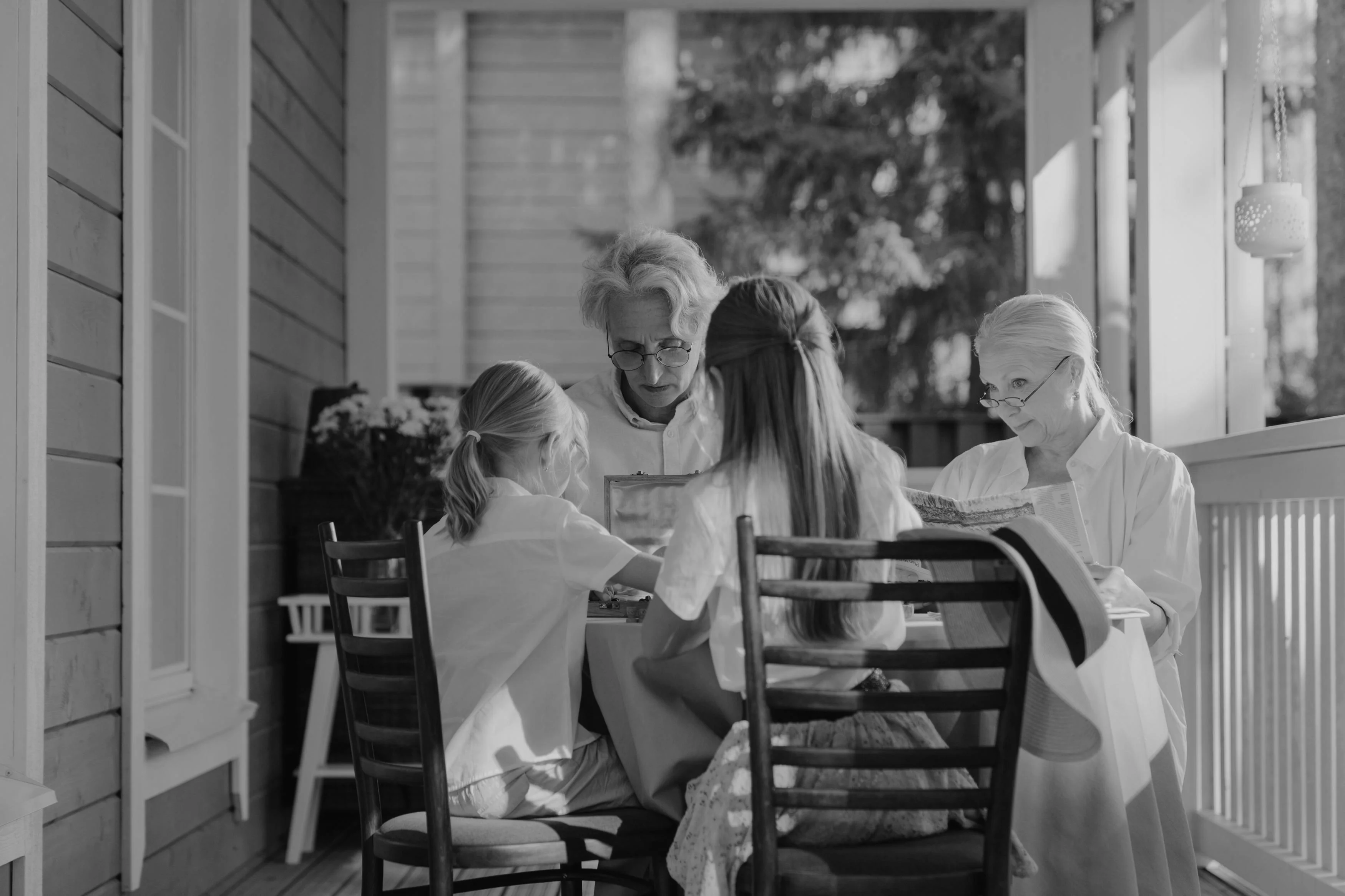 Grandparents with grandchildren looking at photographs — family memory preservation